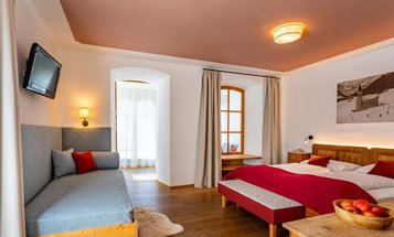 Familiensuite mit Doppelbett und großem Kleiderschrank im Familienhotel Bella Vista in Südtirol.