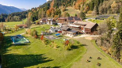 Weitläufige Hotelanlage des Familienhotels Ramsi mit Spielplatz, Sportbereich und herrlichem Bergpanorama in Kärnten.