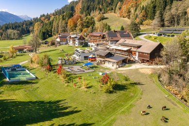 Weitläufige Hotelanlage des Familienhotels Ramsi mit Spielplatz, Sportbereich und herrlichem Bergpanorama in Kärnten.