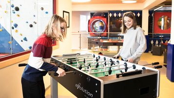 Zwei Teenager spielen im Teens-Club Kicker