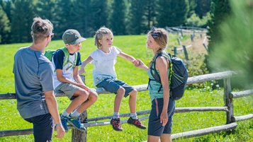 Familie beim Wandern in Südtirol macht eine Pause.