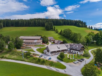 Außenansicht des Familienhotels Der Ponyhof in der Steiermark. Das Hotel ist umgeben von einem großzügigen Außenbereich mit viel Platz für die Kinder zum Spielen.