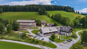 Außenansicht des Familienhotels Der Ponyhof in der Steiermark. Das Hotel ist umgeben von einem großzügigen Außenbereich mit viel Platz für die Kinder zum Spielen.