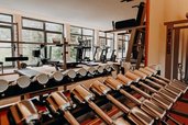 Hanteln und Trainingsgeräte stehen im Fitnessraum des Hotel Sonngastein im Salzburger Land bereit.