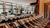 Hanteln und Trainingsgeräte stehen im Fitnessraum des Hotel Sonngastein im Salzburger Land bereit.
