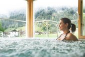 Eine Frau sitzt im Whirlpool im Alpenhotel Kindl in Tirol