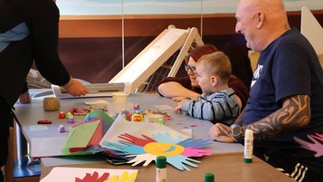 Familie bastelt gemeinsam am Tisch im kreativen Spiel- und Werkbereich des Familien Hotels Seeklause