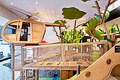Das Spielzimmer "Quaki" hat viele Spielmöglichkeiten für Kinder, zum Beispiel Rutschen, und ein Holz-Hubschrauber, im Familienhotel Allgäuer Berghof.