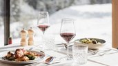 Gedeckter Tisch im Restaurant des Familienhotels Bella Vista in Südtirol. Genießt einen herrlichen Panoramabergblick.