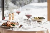 Gedeckter Tisch im Restaurant des Familienhotels Bella Vista in Südtirol. Genießt einen herrlichen Panoramabergblick.