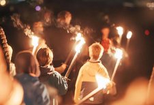 Kinder ziehen mit brennenden Fackeln durch die Dunkelheit bei einem Erlebnisabend im Familienhotel Tirolerhof