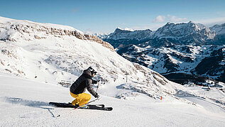 Ein Skifahrer bei der Abfahrt. Die Berge in Südtirol eignen sich für den perfekten Familienurlaub im Winter.
