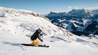 Ein Skifahrer bei der Abfahrt. Die Berge in Südtirol eignen sich für den perfekten Familienurlaub im Winter.