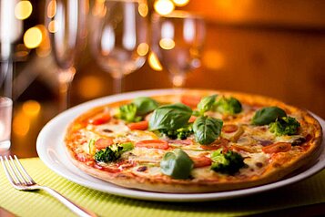 Frisch zubereitete Pizza mit frischen Kräutern und Gemüse im Familienhotel Am Rennsteig im Thüringer Wald.