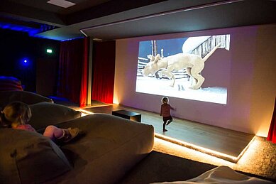 Kinder sehen sich im großen Kino und Theatersaal einen Film an im Familienhotel Ulichshof im Bayerischen Wald