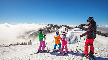 Kinder lernen im Familienurlaub in Kärnten Skifahren auf der Piste.