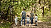 Eine Familie des Familienhotels Seeklause an der Ostsee gehen in der wunderschönen Natur spazieren.