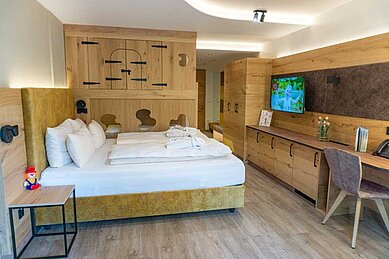 Gemütliches Familienzimmer mit einem Doppelbett und zwei Kinderbetten im Familienhotel Landhaus zur Ohe im Bayerischen Wald.