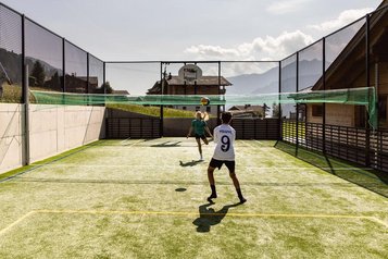 Zwei Kinder spielen Volleyball im Funcourt im Almfamilyhotel Scherer in Tirol.