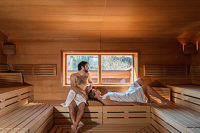 Das Ehepaar entspannt in der Sauna im Familienhotel Das Hopgarten in Tirol.