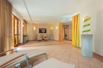 Im Familienhotel Ramsi bietet der lichtdurchflutete Ruheraum mit bequemen Liegen und freundlichen Farben den perfekten Ort zum Entspannen für Groß und Klein