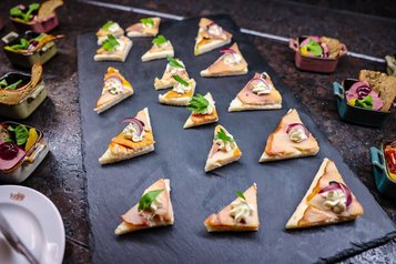 Feine Canapés im Landgut Furterwirt, Genussvolle Häppchen mit Räucherfisch, Creme und frischen Kräutern auf Schieferplatte angerichtet