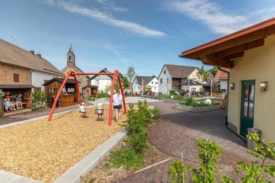 Spielplatz im Familienhotel Ottonenhof im Sauerland mit Schaukel und Blick auf den Innenhof.