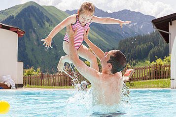 Papa und Tochter planschen im Pool vom Familienhotel Kaiserhof Tiroler Zugspitzarena.