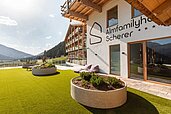 Ausblick von der Gartenanlage auf den Eingangsbereich im Familienhotel Almfamilyhotel Scherer in Tirol.