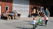 Familien spielen draußen auf dem Hof des Familienhotels Monikas Ferienhof im Sauerland.