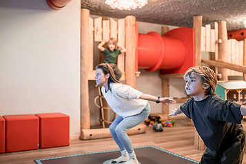 Mutter spielt mit ihren beiden Kindern auf dem Indoor-Spielplatz des Familienhotels Alpenhof Dolomit Family