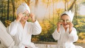 Kinder mit Bademänteln und Gurkenscheiben bei der Wellnesszeit im Familienhotel Das Bayrischzell
