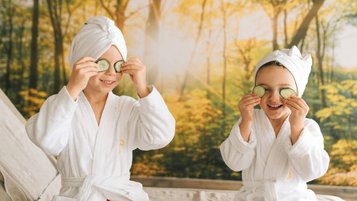 Kinder mit Bademänteln und Gurkenscheiben bei der Wellnesszeit im Familienhotel Das Bayrischzell