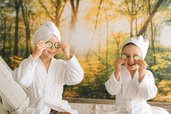 Kinder mit Bademänteln und Gurkenscheiben bei der Wellnesszeit im Familienhotel Das Bayrischzell