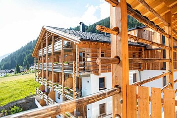 Blick vom Balkon auf die Landschaft und das Nebengebäude im Familienhotel Almfamilyhotel Scherer in Tirol.