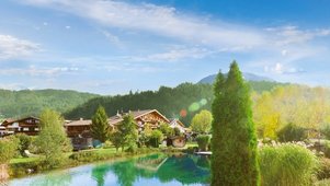 Außenansicht des Familienhotels Landgut Furtherwirt mit blumengeschmückten Balkonen und traditioneller Holzfassade.