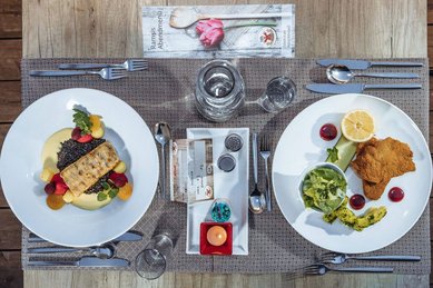 Abwechslungsreich gedeckter Esstisch mit Fischfilet und Schnitzel im Familienhotel Ramsi.
