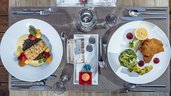 Abwechslungsreich gedeckter Esstisch mit Fischfilet und Schnitzel im Familienhotel Ramsi.