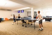 Spielzimmer für Kinder mit vielen Spielmöglichkeiten, wie Kicker, Airhockey und einer Bowlingbahn im Almfamilyhotel Scherer in Obertilliach in Tirol.