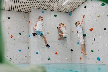 Kletterwand mit drei Kindern