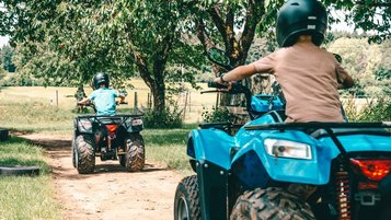 Kinder drehen mit ihren Quads rasante Runden auf dem Gelände vom Familienhotel Friedrichshof.