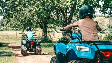 Kinder drehen mit ihren Quads rasante Runden auf dem Gelände vom Familienhotel Friedrichshof.