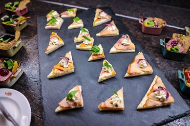 Feine Canapés im Landgut Furterwirt, Genussvolle Häppchen mit Räucherfisch, Creme und frischen Kräutern auf Schieferplatte angerichtet