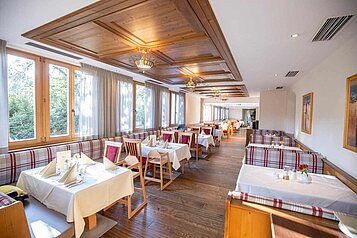 Gemütliches Restaurant mit Eckbänken und Kinderhochstühlen im Familienhotel Das Hopfgarten in Tirol.