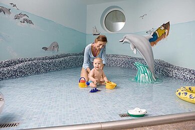 Mutter und Baby planschen gemeinsam im Babybecken des Familienhotels Sonnenpark im Sauerland.