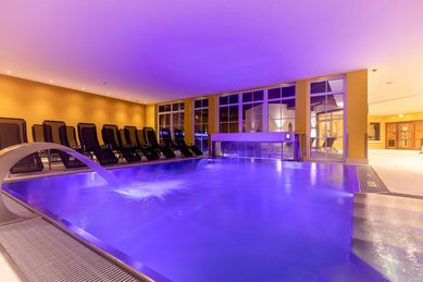 Indoor Therme mit Ambientebeleuchtung und Liegen zum Entspannen im Familienhotel Galtenberg Family & Wellness Resort in Tirol.