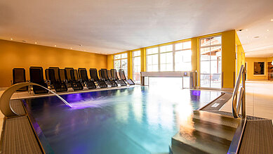 Indoor Therme mit Ambientebeleuchtung und Liegen zum Entspannen im Familienhotel Galtenberg Family & Wellness Resort in Tirol.