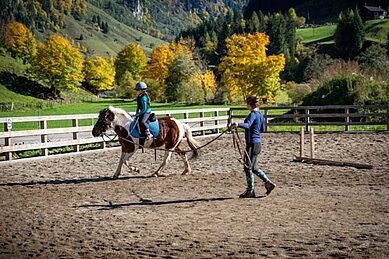 Kind bekommt im Familienhotel Oberkarteis im Salzburger Land Reitstunden.