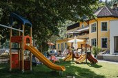 Ein Spielplatz mit Rutsche vor dem Kinderhotel Bruckwirt in Oberösterreich.