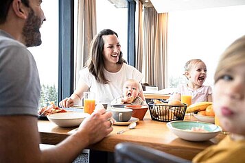 Familie mit drei Kindern beim gemütlichen und ausgiebigen Frühstück im Allgäuer Berghof.